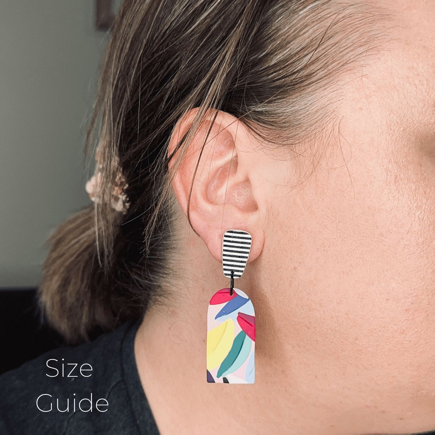 Earring worn by a person with a size guide label