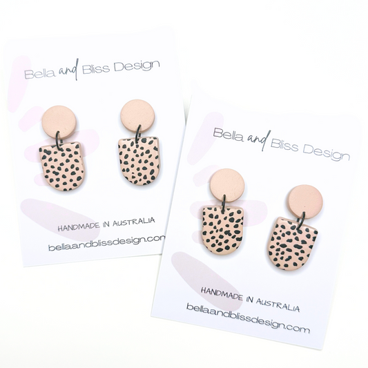 Pair of earrings with spotted design on a white background with 'Bella and Bliss Design' branding.