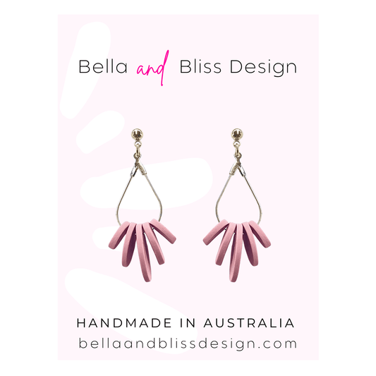 Pale Pink earrings with gold hooks on a light pink background, featuring 'Bella and Bliss Design'.