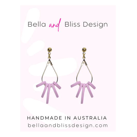 Pink earrings with gold accents on a light pink background, featuring 'Bella and Bliss Design'.