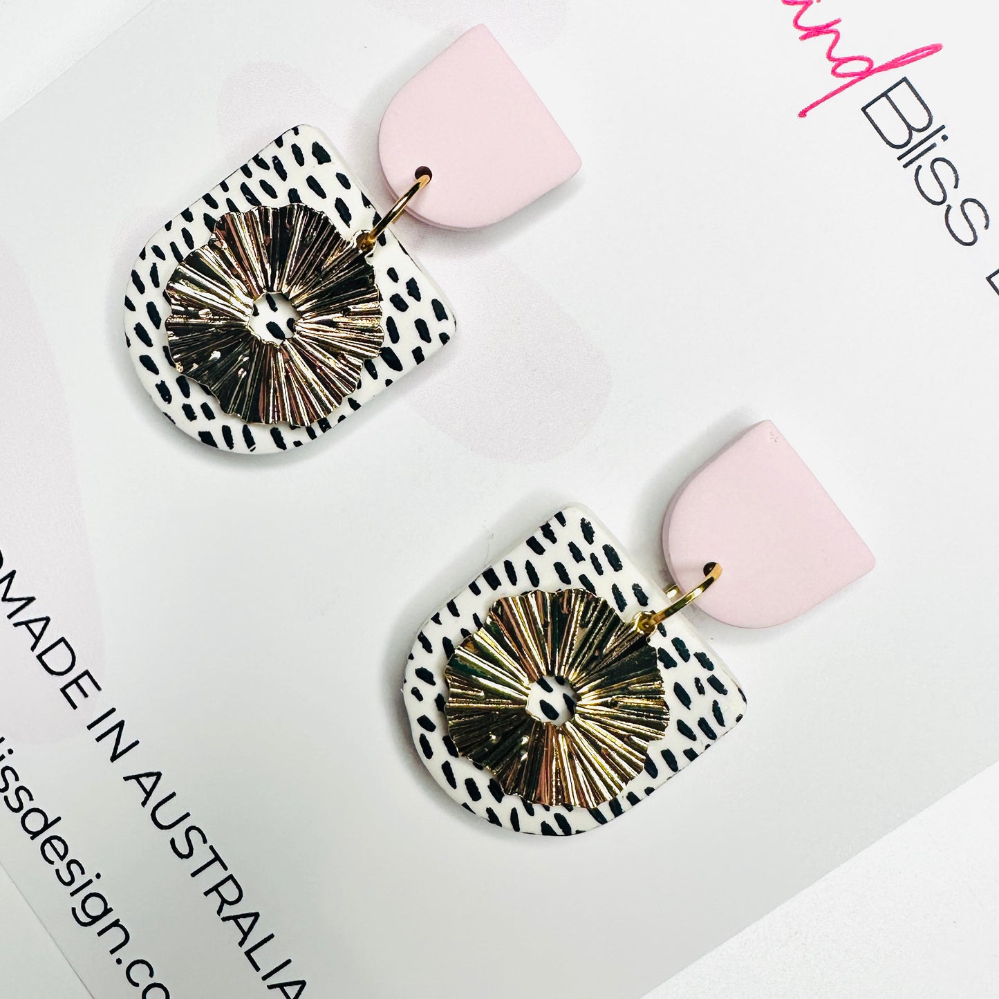 Light pink top on black dot on white clay with gold flower