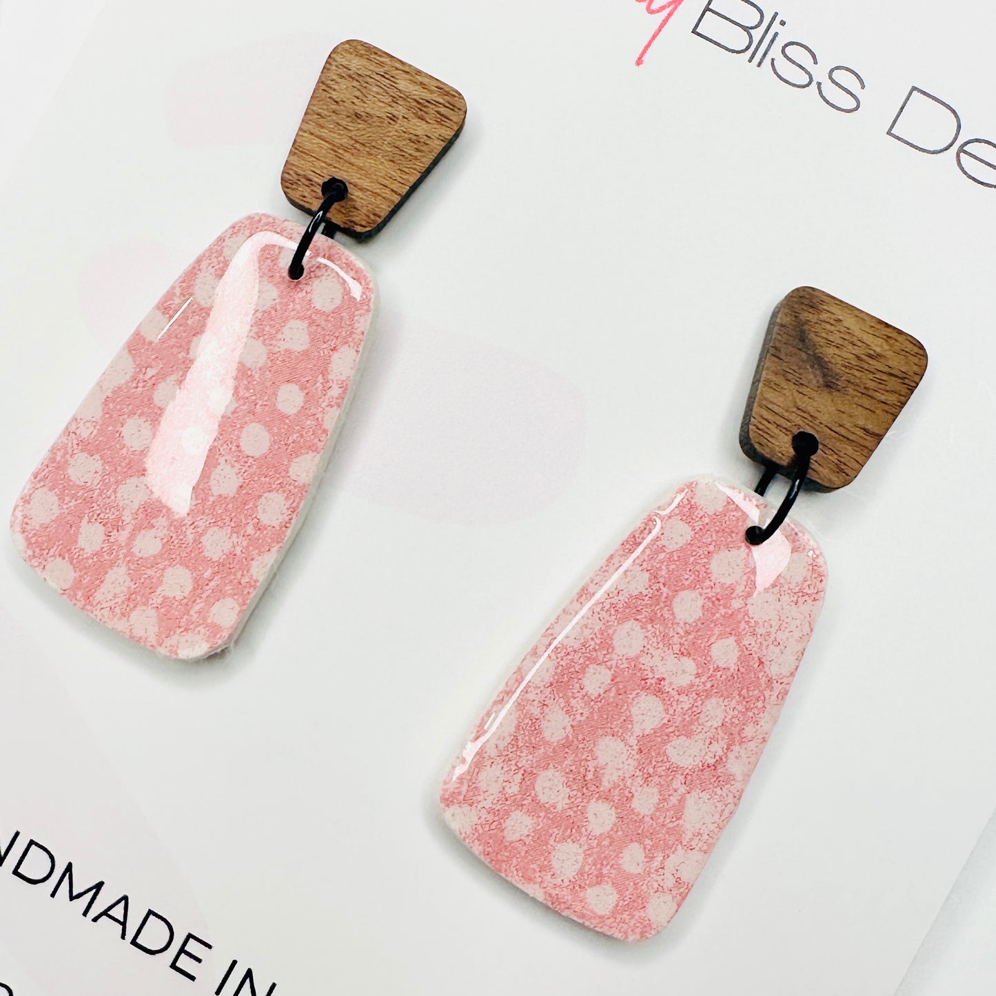 Pink earrings with wooden tops on a white background, featuring 'Bella and Bliss Design'.