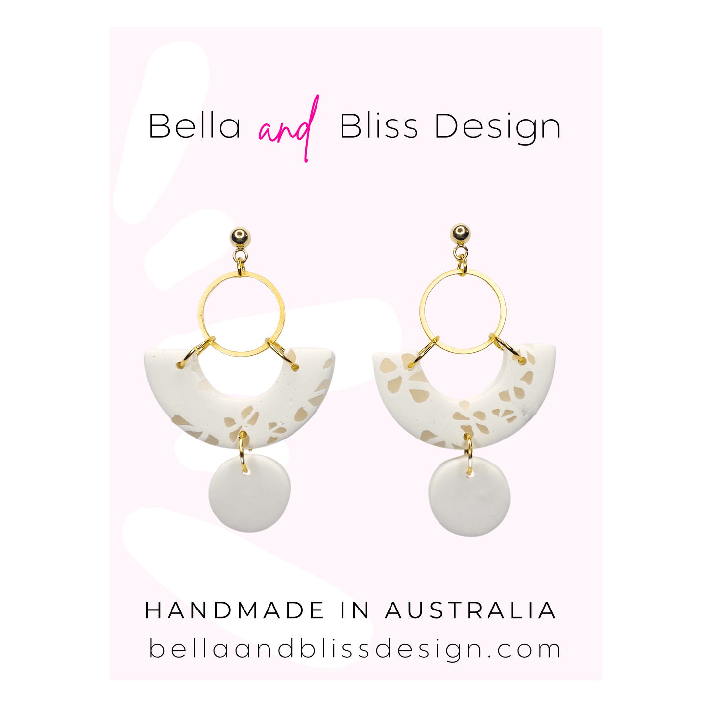 White earrings with gold accents on a pink background, featuring Bella and Bliss Design branding.