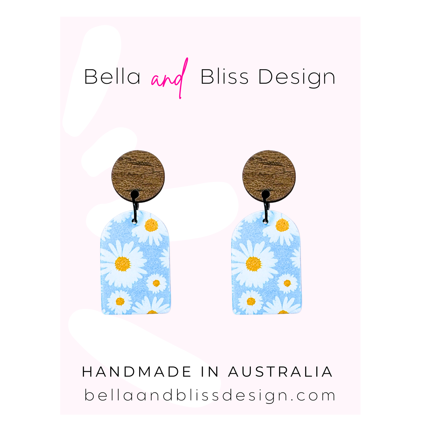 Pair of earrings with floral design on a pink background, featuring 'Bella and Bliss Design'.