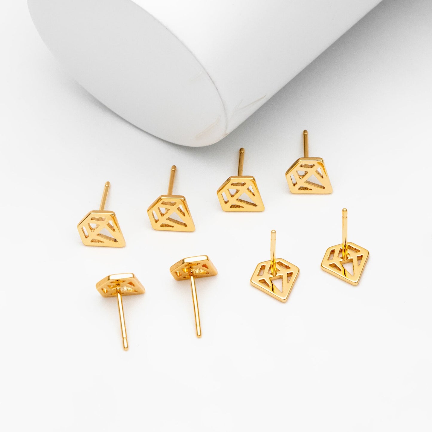 A pair of 18K gold plated mini stud earrings displayed on a branded card with 'Bella and Bliss Design' written on it.