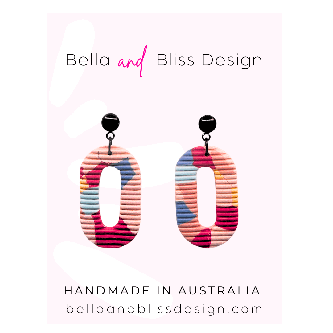 Colorful earrings with 'Bella and Bliss Design' branding on a light pink background.