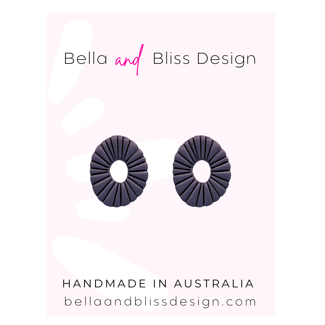 Pair of purple circular earrings on a pink background with 'Bella and Bliss Design' branding.