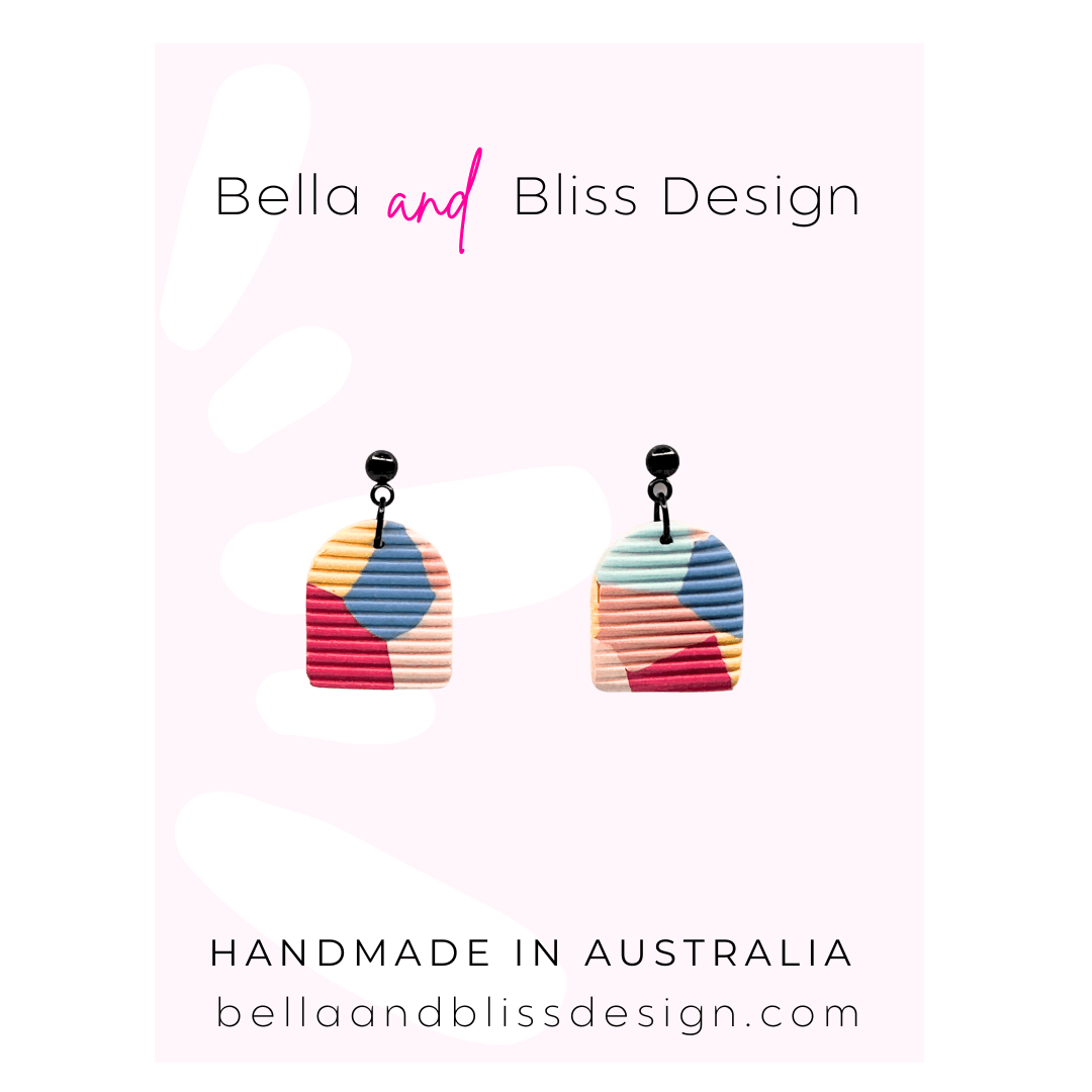 Colorful earrings with 'Bella and Bliss Design' branding on a light pink background.