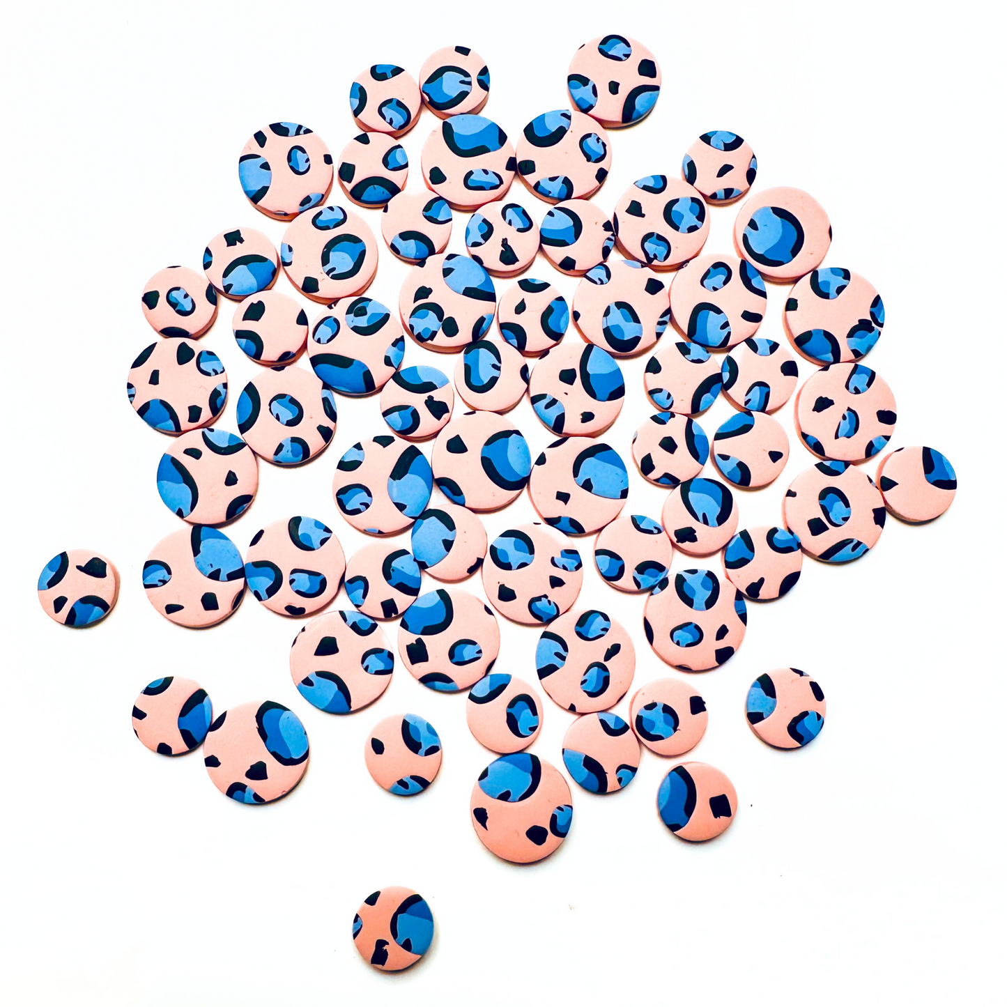 A collection of stud earrings featuring a leopard print pattern with blue and coral color spots on a white background.