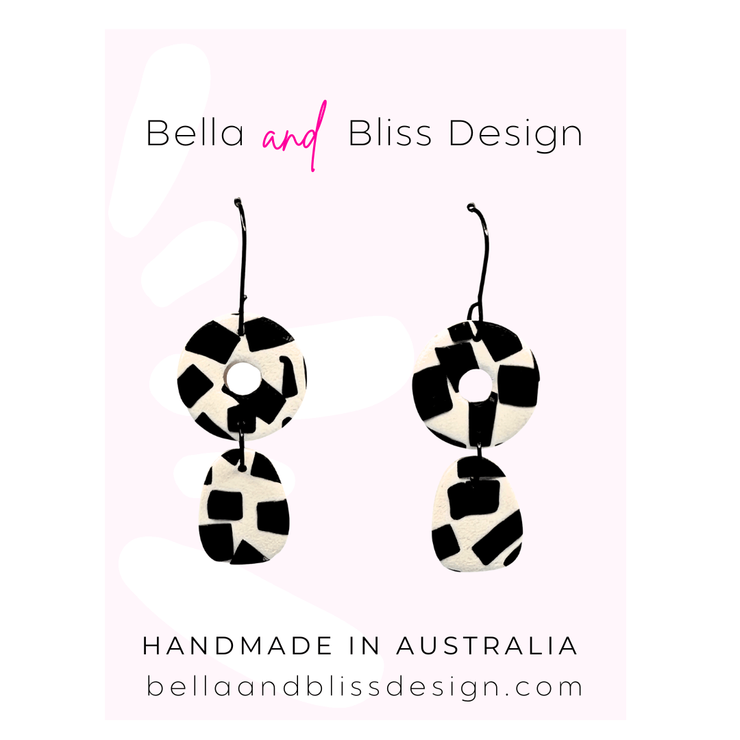 Black and white checkered earrings with 'Bella and Bliss Design' branding on a pink gradient background.