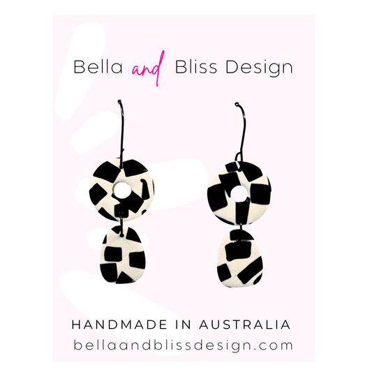 Black and white checkered earrings with 'Bella and Bliss Design' branding on a pink gradient background.