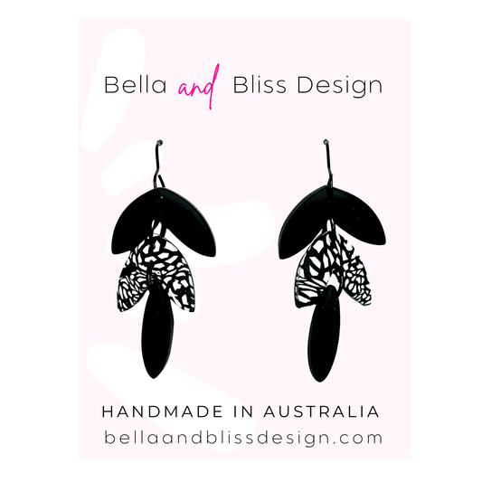 Butterfly-themed earrings with 'Bella and Bliss Design' branding on a light pink background.