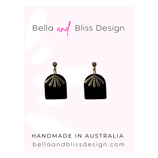 Black earrings with gold accents on a light pink background, featuring Bella and Bliss Design branding.