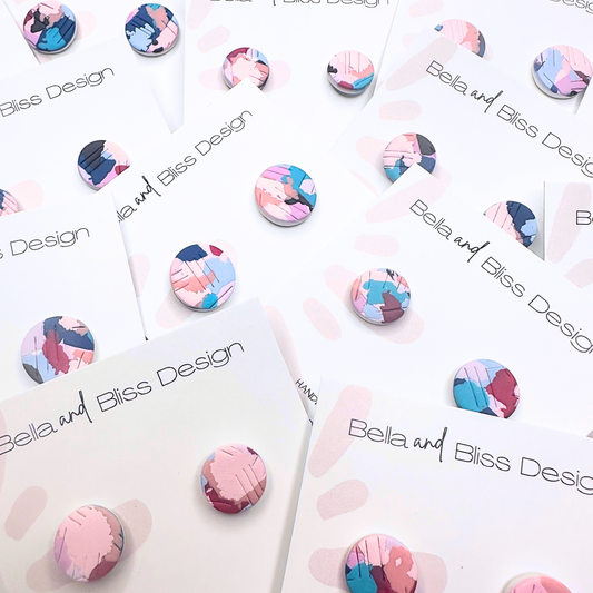 Colorful earring designs on white cards with 'Bella and Bliss Design' branding.