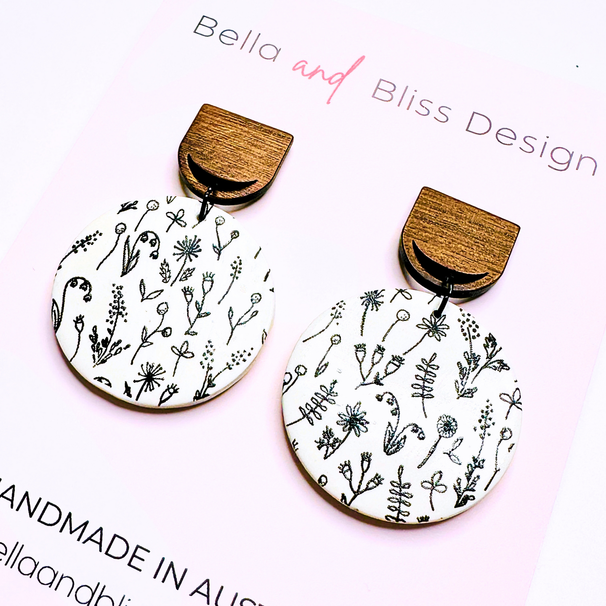 Wooden earrings with floral patterns on a white background, branded 'Bella and Bliss Design'.
