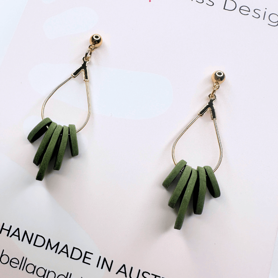 Close up of earring design with gold hooks on a light pink background, featuring 'Bella and Bliss Design'.