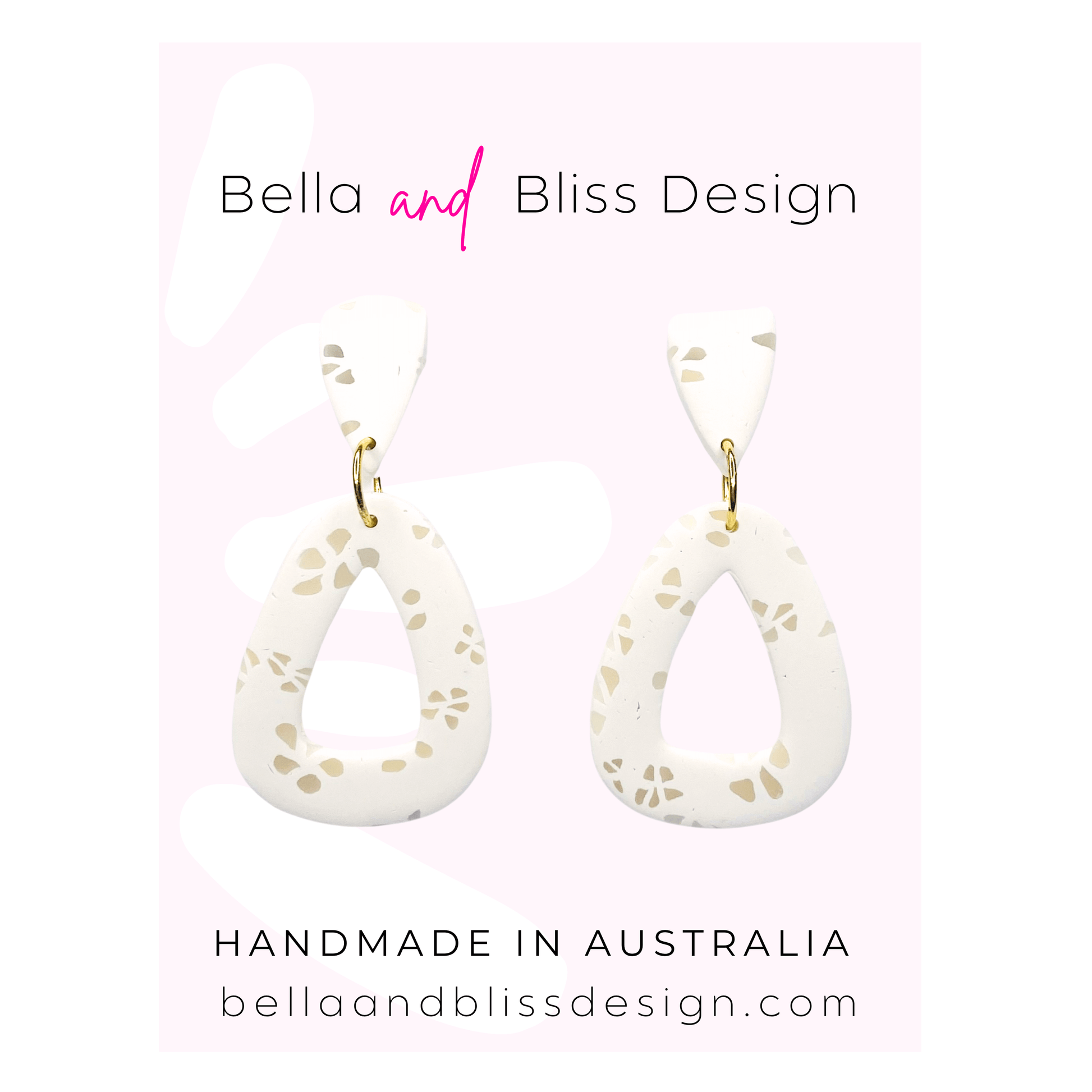 White teardrop earrings with gold accents on a pink background, featuring Bella and Bliss Design branding.