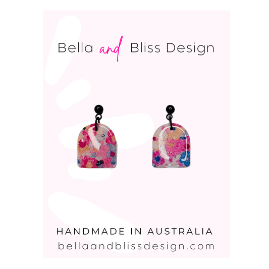 Colorful earrings with floral design on a white background, branded as Bella and Bliss Design.