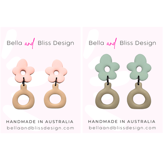 Flower-shaped earrings with pink floral tops and beige circular bases on a light pink background, featuring 'Bella and Bliss Design'.
