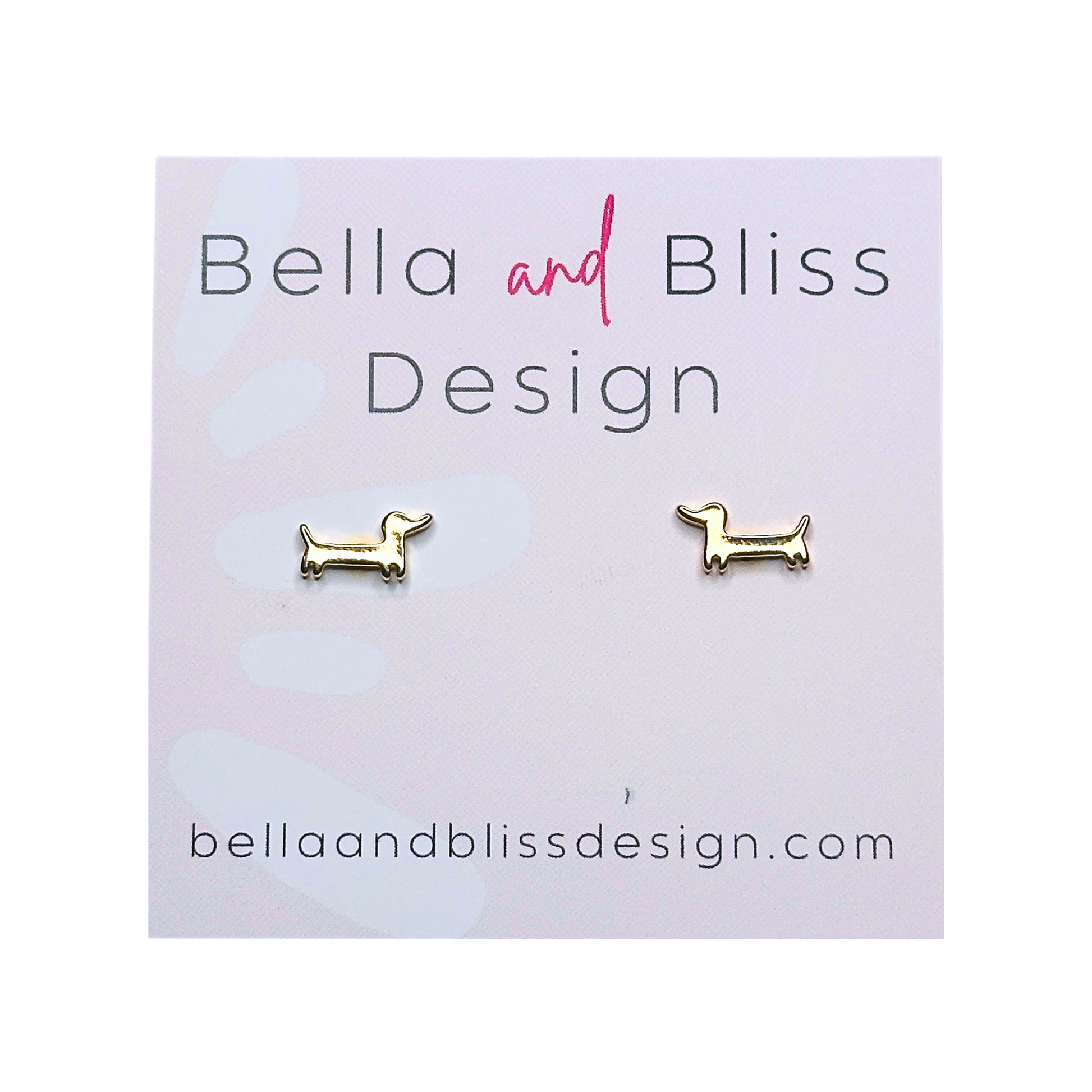 A pair of 18K gold plated mini stud earrings in the shape of a dachshund, presented on a white background with 'Bella and Bliss Design' branding.