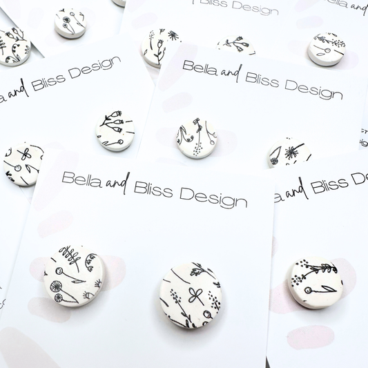 Earrings with floral designs on a white background with 'Bella and Bliss Design' branding.