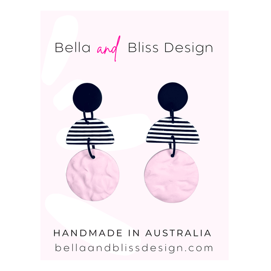 Earrings with black and white striped design on pink background, branded 'Bella and Bliss Design'.