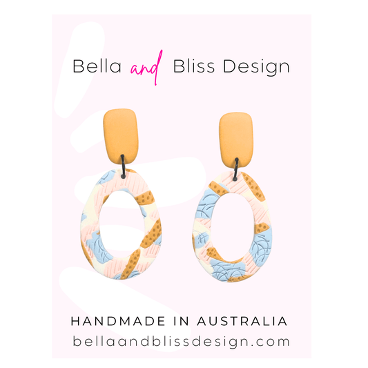 Earrings with floral pattern on a pink background, branded as Bella and Bliss Design.