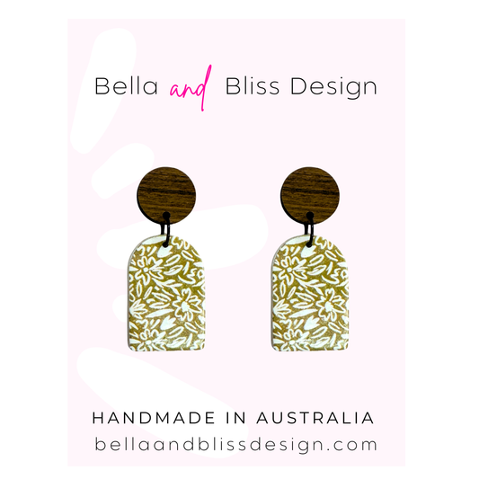 Floral earrings on a card with 'Bella and Bliss Design' branding.