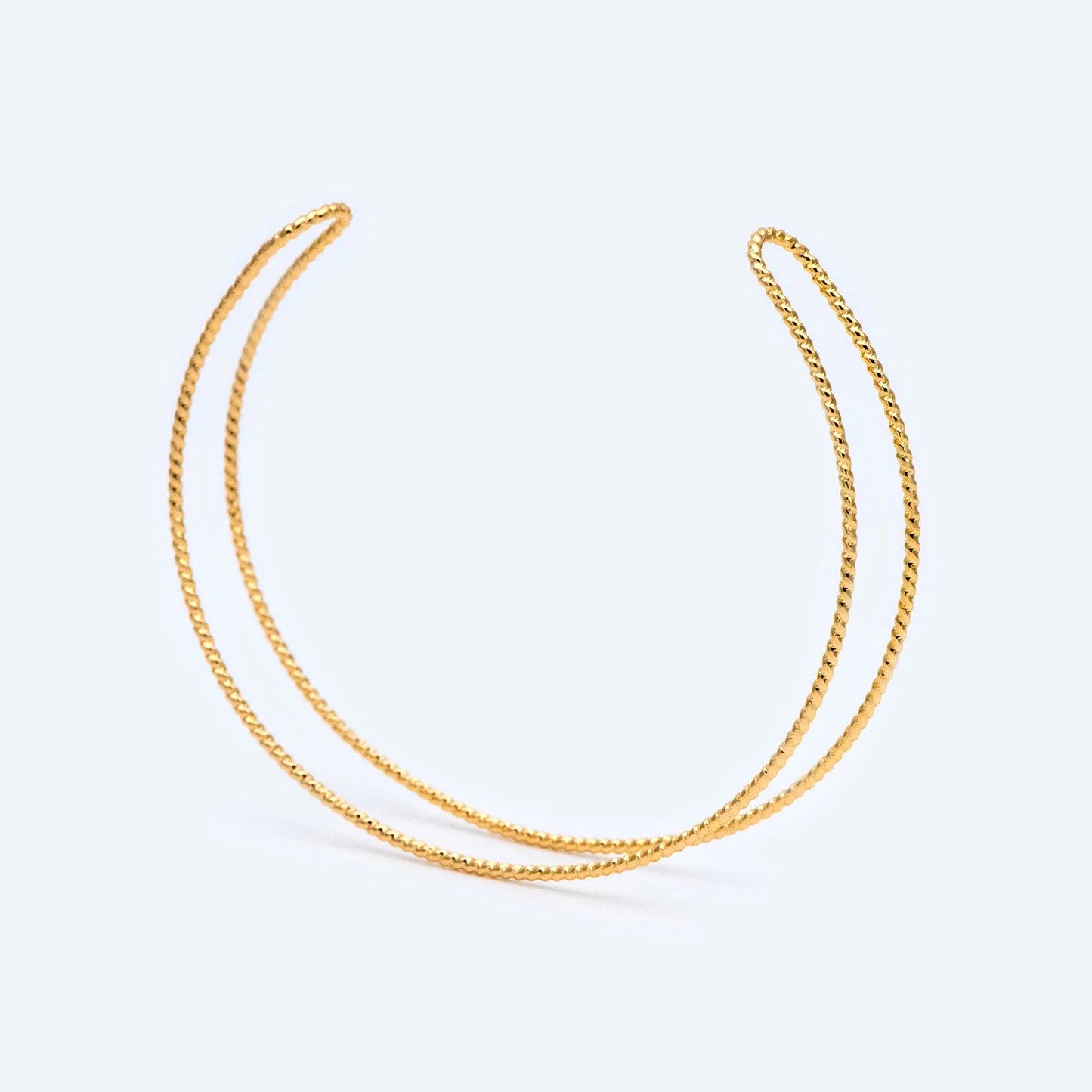 Two gold necklaces on a light gray background