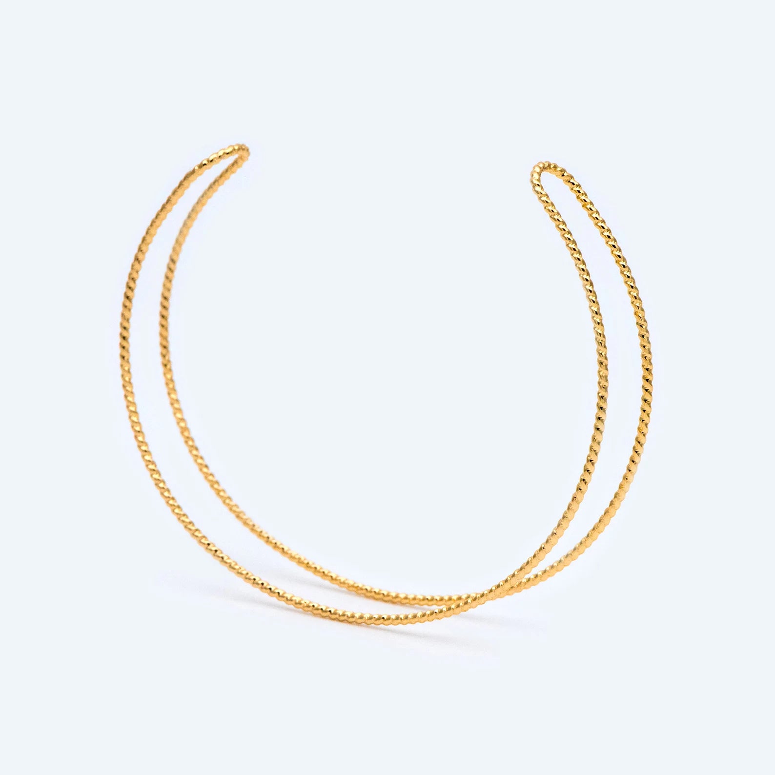 Two gold necklaces on a light gray background