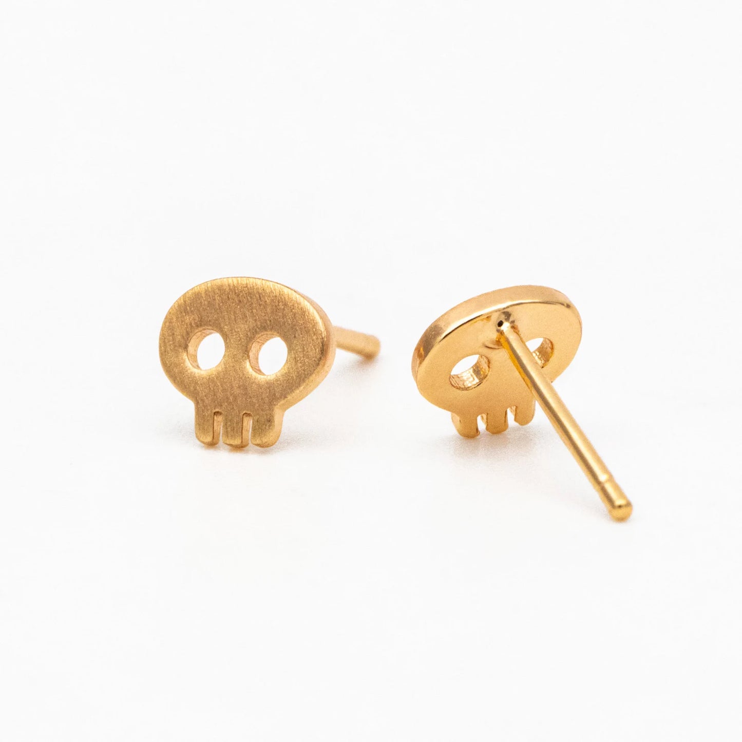 Gold skull-shaped earrings on a white background