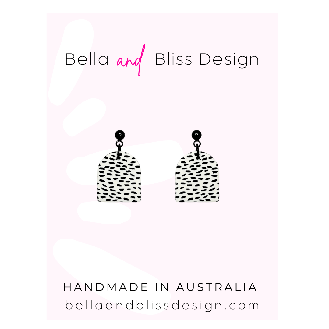 Pair of earrings with black and white pattern on a pink gradient background with 'Bella and Bliss Design' branding.