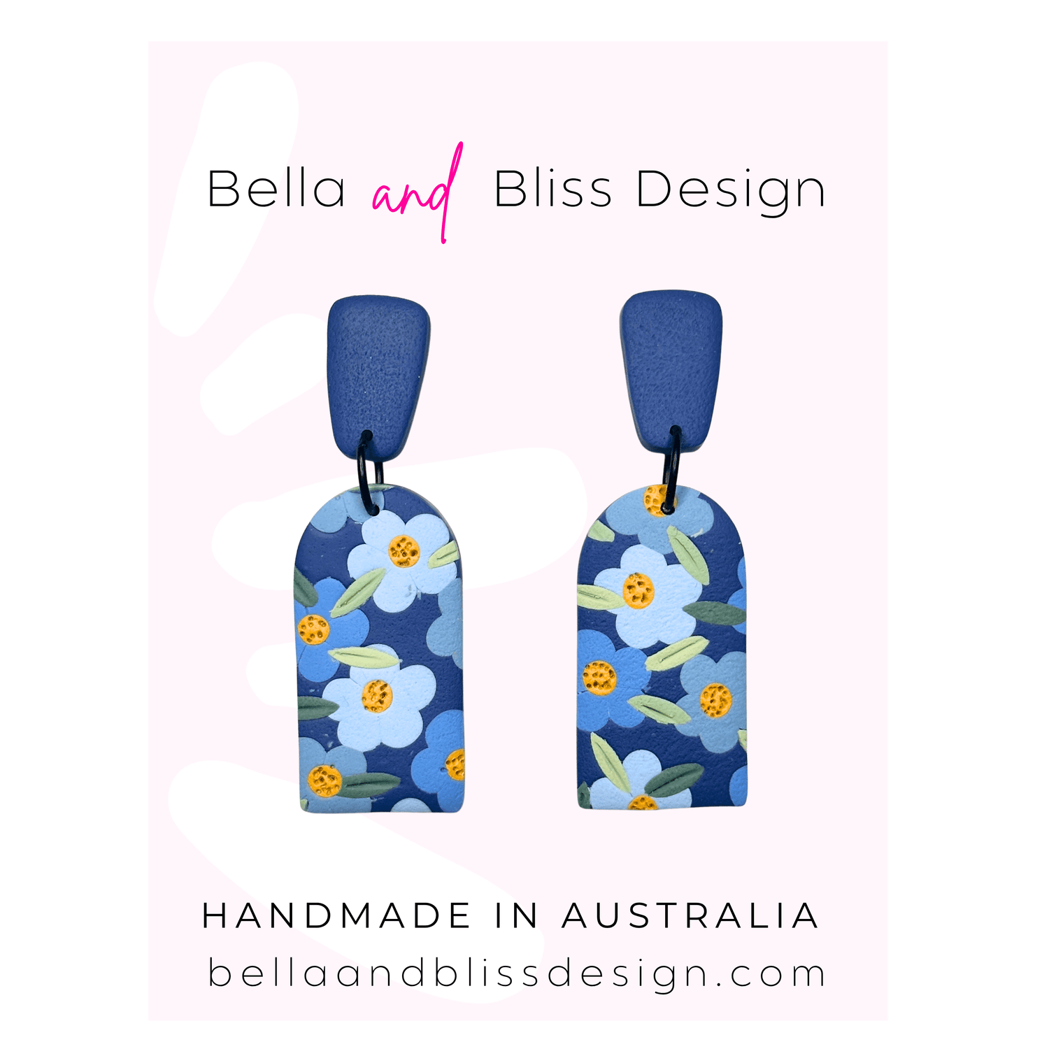 Blue floral earrings with 'Bella and Bliss Design' branding on a pink background