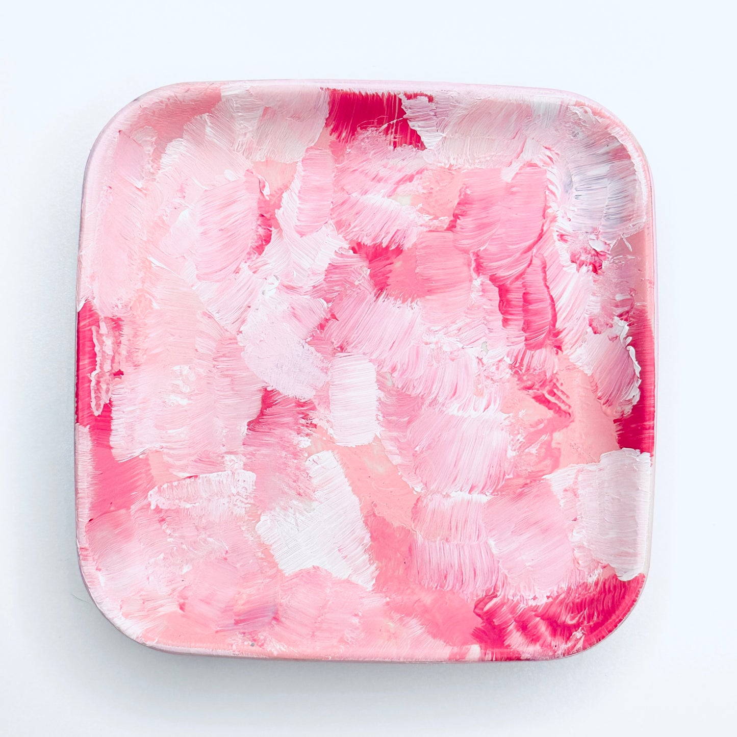 A hand-painted rectangular jewellery dish with a pink and white color scheme.