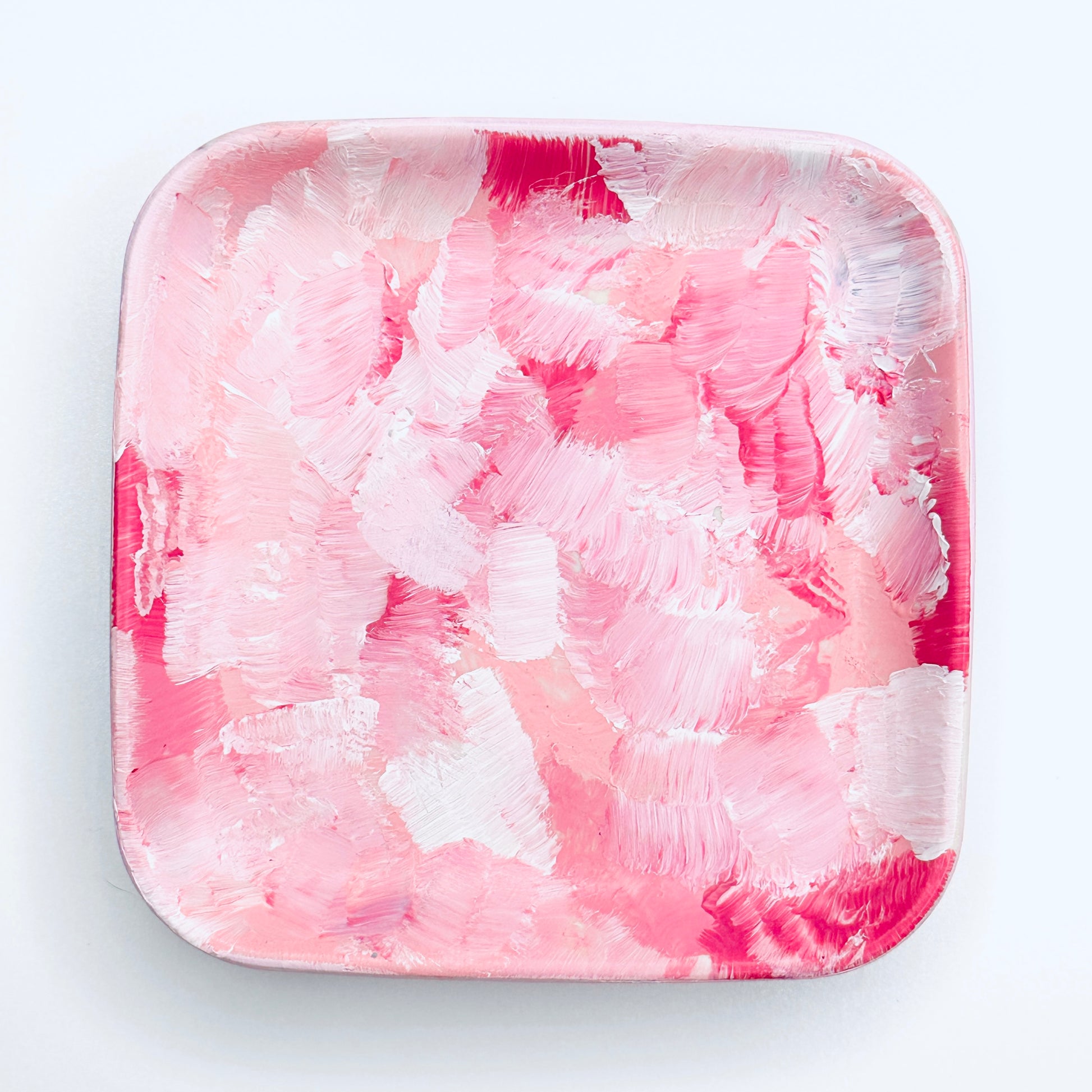 A hand-painted rectangular jewellery dish with a pink and white color scheme.