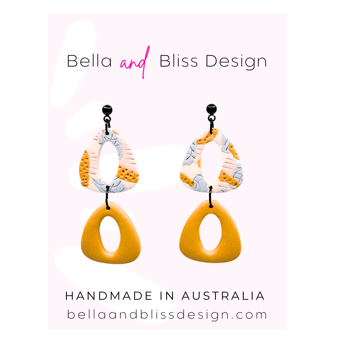 Colourful earrings with 'Bella and Bliss Design' branding on a light pink background.