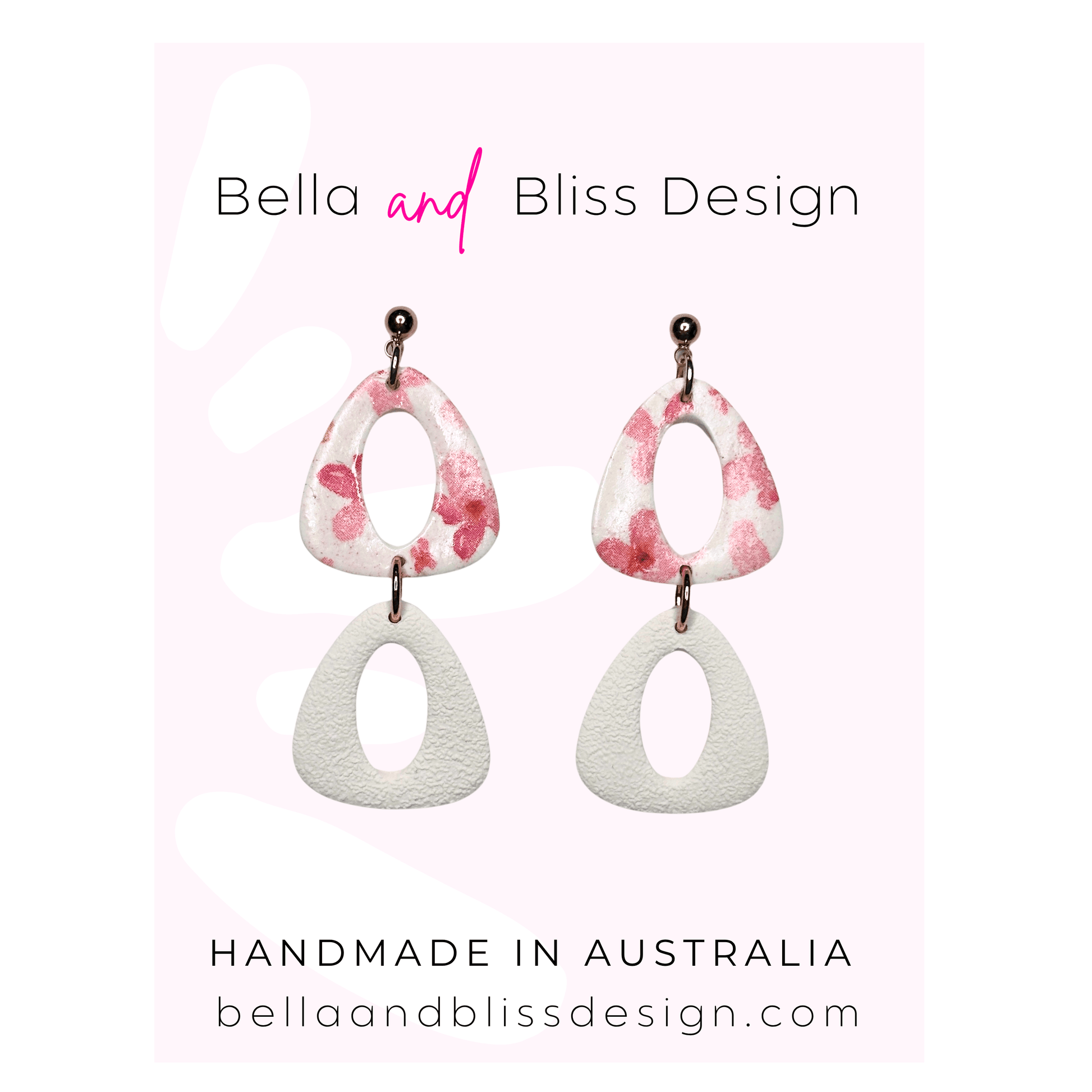 Pair of earrings with pink and white design on a light pink background, featuring 'Bella and Bliss Design'.