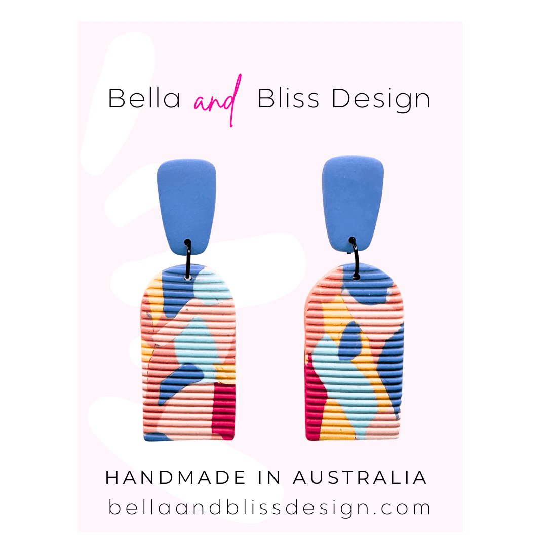 Colorful earrings with 'Bella and Bliss Design' branding on a light pink background.