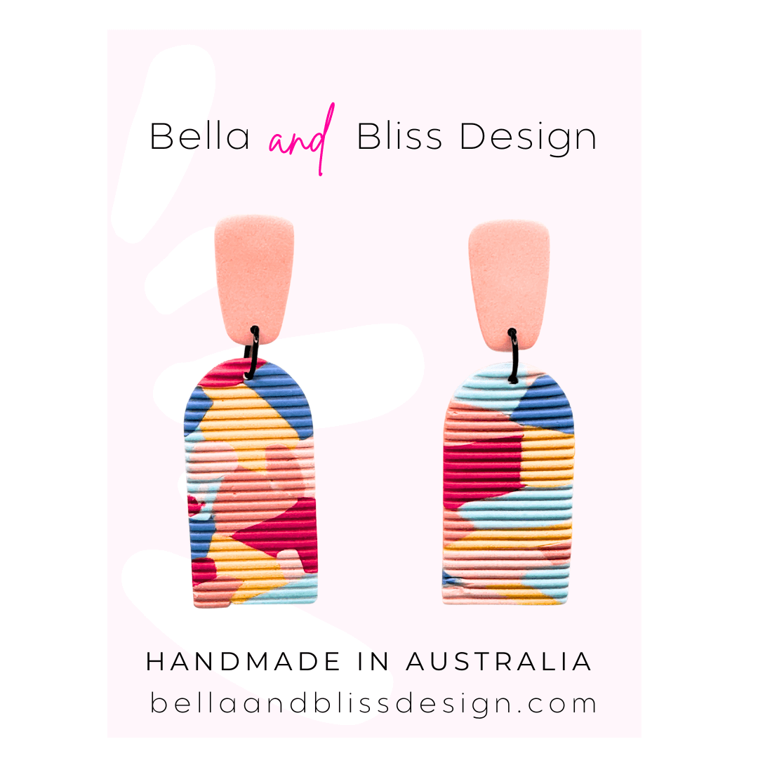 Colorful earrings with 'Bella and Bliss Design' branding on a light pink background.