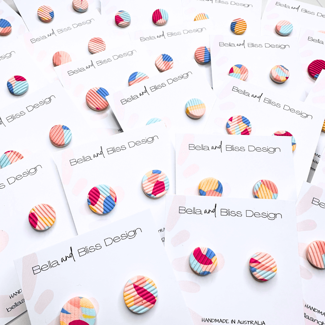 Colorful striped earrings on display with 'Bella and Bliss Design' branding.